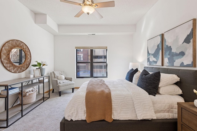carpeted bedroom featuring a ceiling fan and visible vents