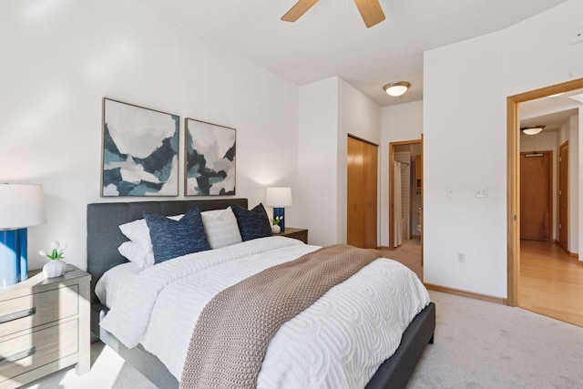 bedroom featuring ceiling fan, light colored carpet, and baseboards