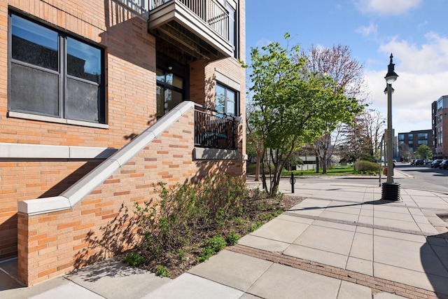 exterior space with a balcony and brick siding
