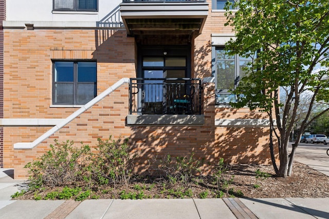 view of exterior entry featuring brick siding