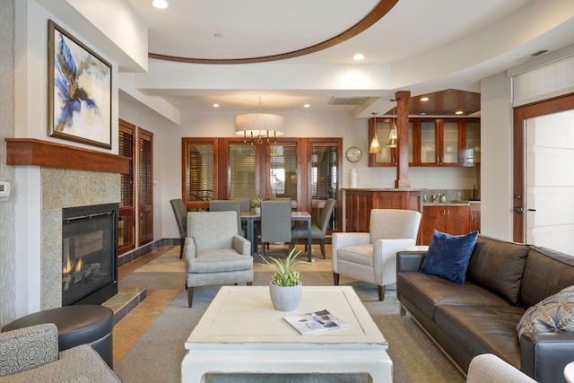 living room featuring recessed lighting, a tiled fireplace, visible vents, and an inviting chandelier