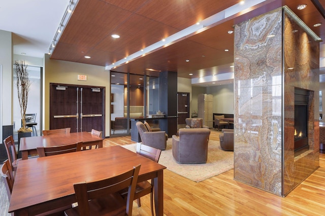 interior space featuring wooden ceiling, light wood-type flooring, and a fireplace
