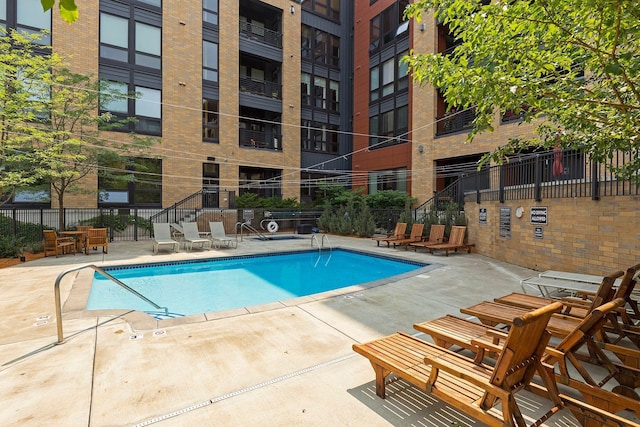 pool with fence and a patio