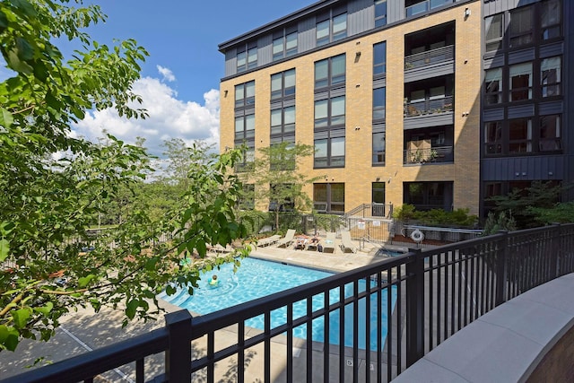 community pool with fence and a patio area