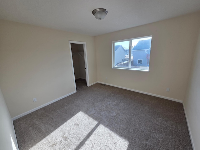 carpeted spare room featuring baseboards