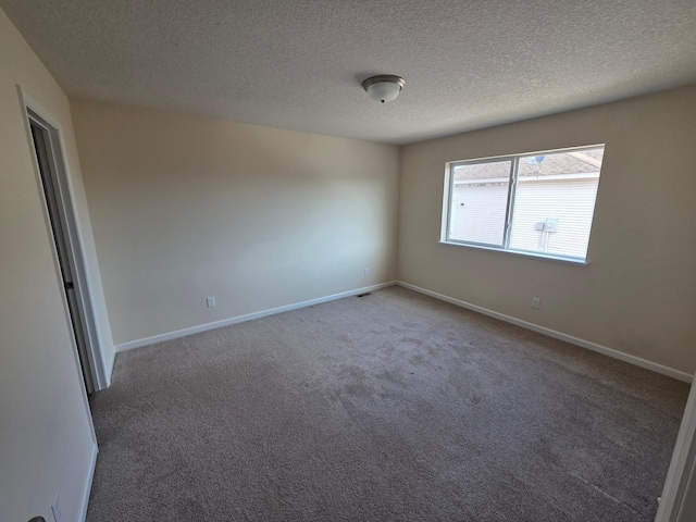 unfurnished room featuring a textured ceiling, baseboards, and carpet floors