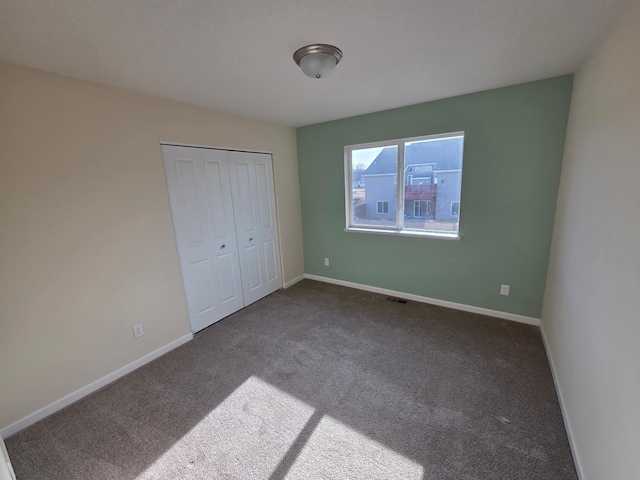 unfurnished bedroom with visible vents, baseboards, carpet floors, and a closet