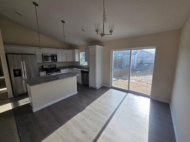 kitchen with visible vents, a kitchen island, dark wood finished floors, appliances with stainless steel finishes, and white cabinets