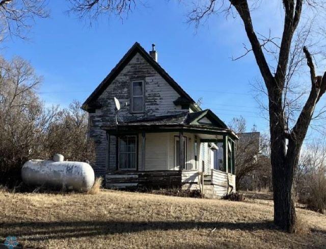 view of front of home with a porch and a chimney