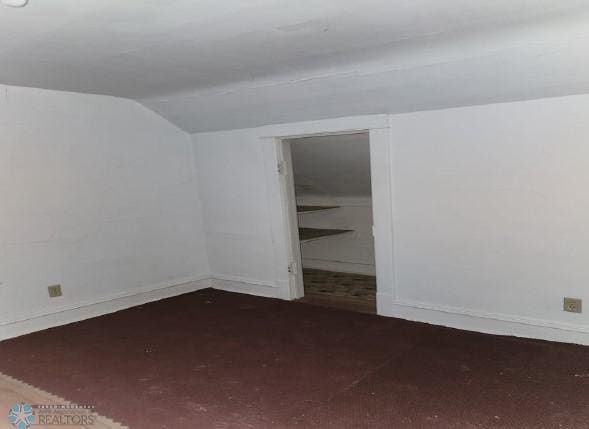 empty room featuring lofted ceiling