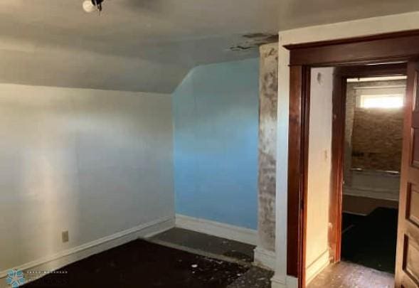 bonus room featuring baseboards and lofted ceiling