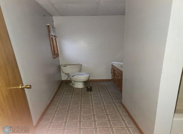 bathroom with baseboards, toilet, vanity, and tile patterned flooring