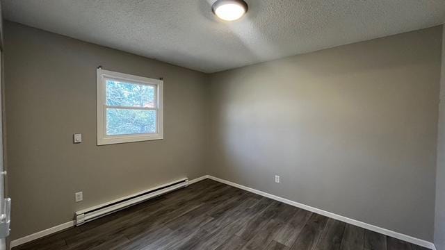 empty room with a baseboard radiator, baseboards, dark wood-type flooring, and a textured ceiling