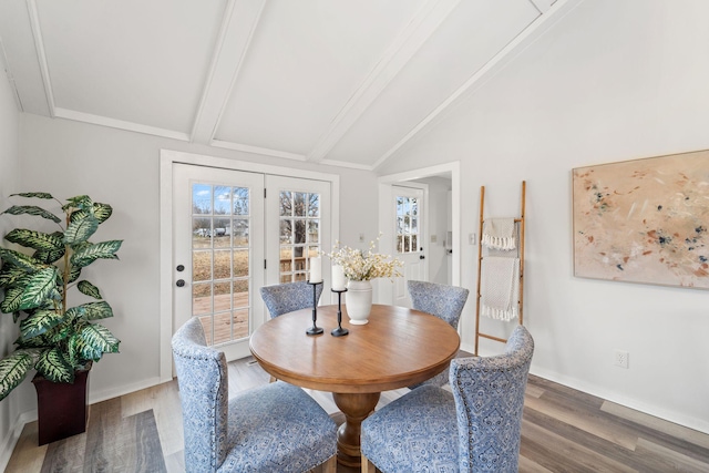 dining space featuring vaulted ceiling with beams, wood finished floors, and baseboards