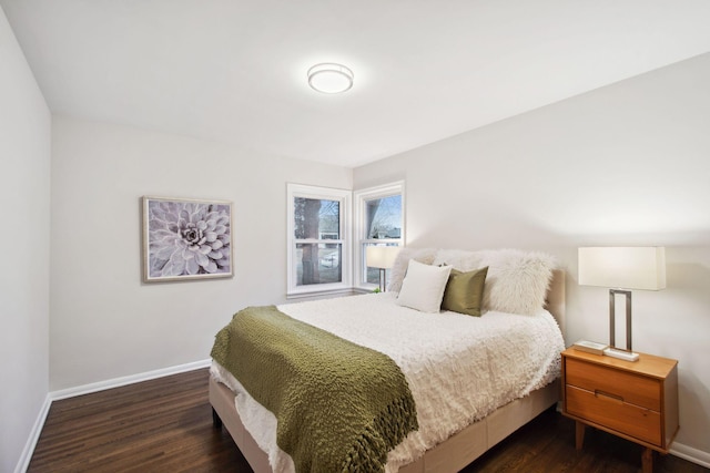 bedroom with baseboards and dark wood-style flooring