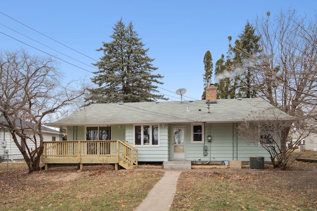 ranch-style home featuring a chimney, central AC, and a shingled roof