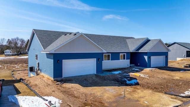 ranch-style house with central AC unit, a garage, and a shingled roof