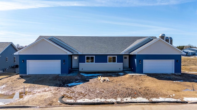 ranch-style house featuring an attached garage, driveway, and roof with shingles