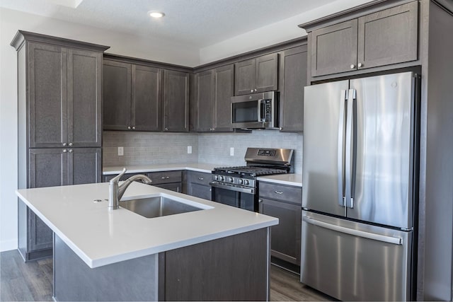 kitchen with a sink, tasteful backsplash, dark wood-style floors, stainless steel appliances, and dark brown cabinetry