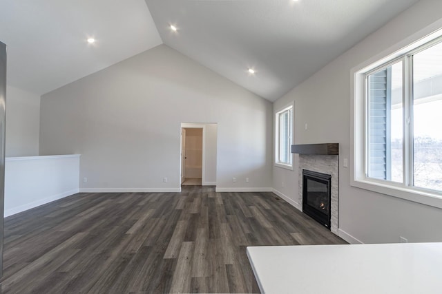 unfurnished living room featuring baseboards, high vaulted ceiling, dark wood finished floors, recessed lighting, and a fireplace