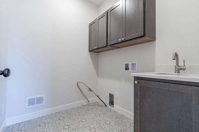 laundry area featuring visible vents, baseboards, washer hookup, cabinet space, and a sink