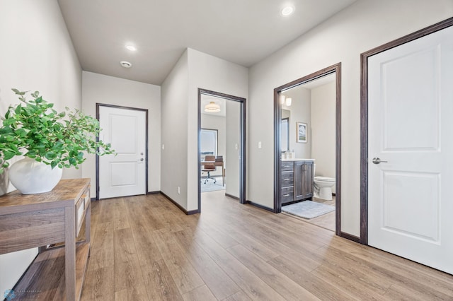 entryway featuring light wood-style flooring, recessed lighting, and baseboards