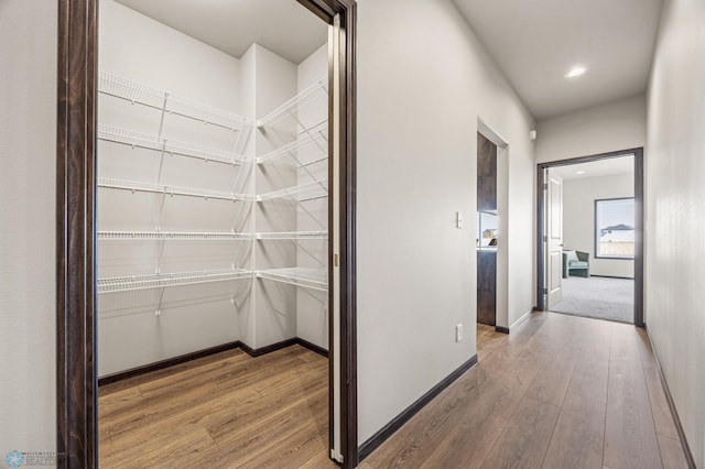 corridor with recessed lighting, baseboards, and wood-type flooring