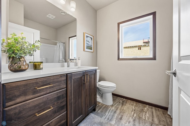 full bathroom with visible vents, baseboards, toilet, wood finished floors, and vanity