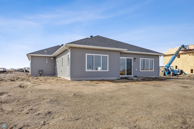 rear view of house with roof with shingles