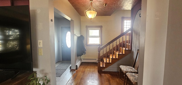 entryway featuring baseboard heating, stairs, and hardwood / wood-style flooring