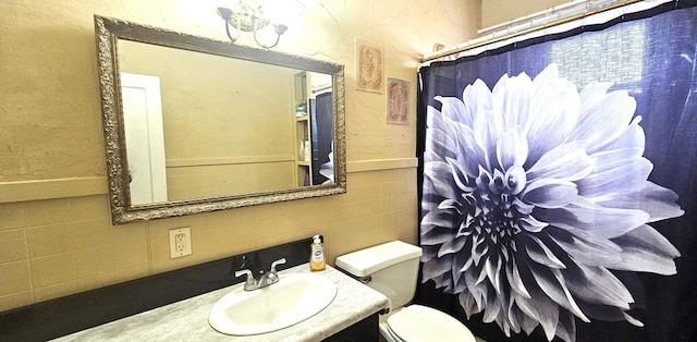 full bathroom with vanity, tile walls, curtained shower, and toilet