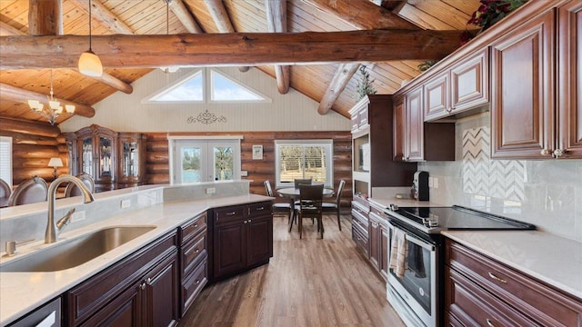 kitchen featuring a sink, electric range, wood finished floors, and light countertops