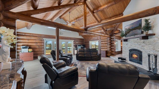 living area featuring wood finished floors, high vaulted ceiling, a fireplace, french doors, and beamed ceiling