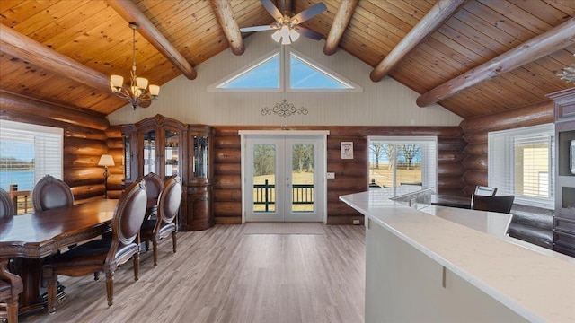 dining space featuring light wood-type flooring, beam ceiling, rustic walls, french doors, and wood ceiling