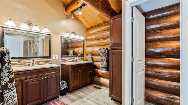 bathroom with wood finished floors, two vanities, wood ceiling, and a sink