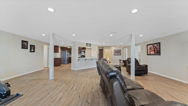 living room with recessed lighting, light wood-type flooring, and baseboards