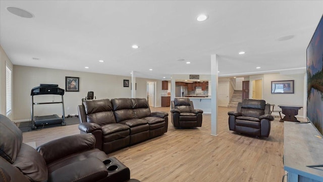 living room with recessed lighting, stairway, and light wood-style flooring