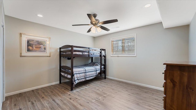 bedroom with visible vents, baseboards, light wood-style floors, and a ceiling fan