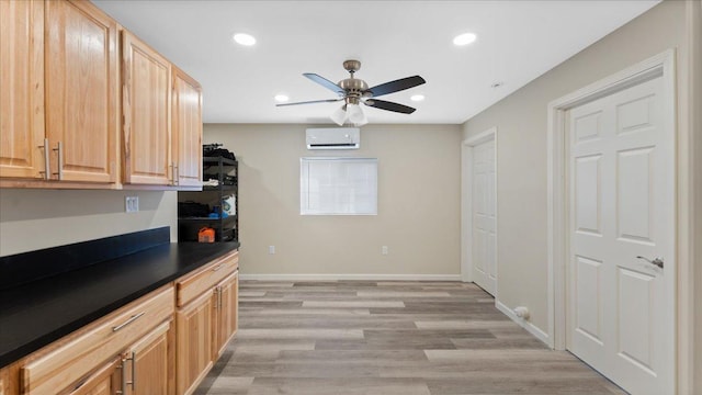 kitchen with dark countertops, a wall unit AC, recessed lighting, light wood finished floors, and ceiling fan