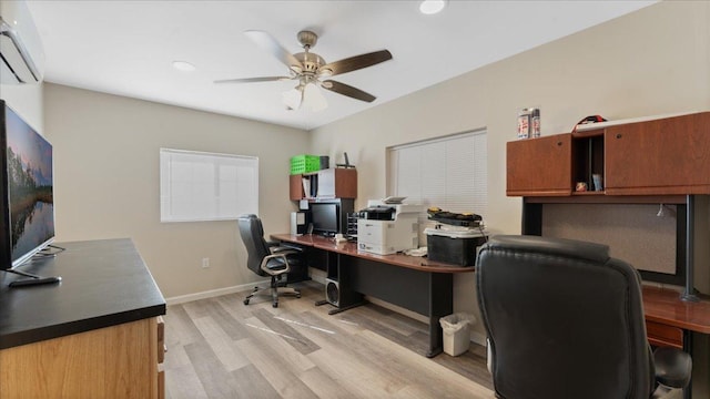 office area featuring a ceiling fan, light wood-type flooring, a wall mounted air conditioner, and baseboards