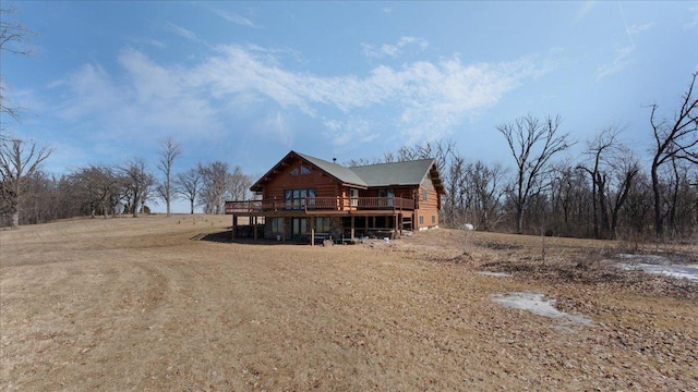 back of property featuring log siding and a wooden deck