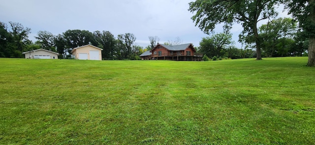 view of yard featuring a detached garage, an outbuilding, and a deck