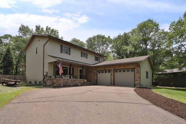 8403 Red Pine Cir, Baxter, MN 56425 - view of front of house with covered porch, an attached garage, driveway, and stone siding