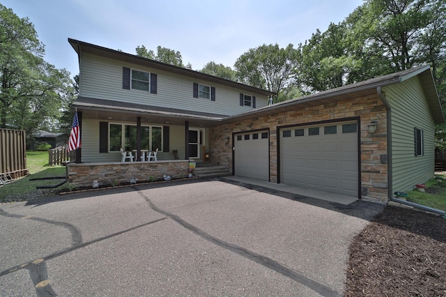 8403 Red Pine Cir, Baxter, MN 56425 - view of front of home with stone siding, a porch, an attached garage, and driveway