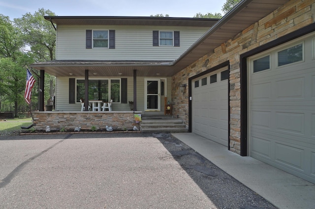 8403 Red Pine Cir, Baxter, MN 56425 - view of front facade with stone siding, driveway, covered porch, and an attached garage