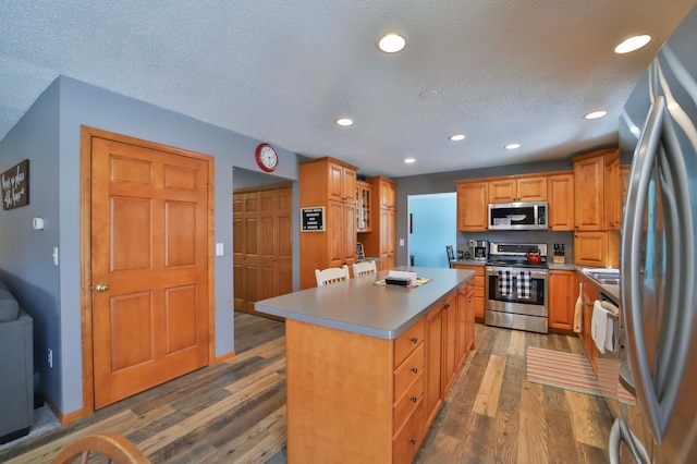 8403 Red Pine Cir, Baxter, MN 56425 - kitchen featuring appliances with stainless steel finishes, a center island, dark wood-type flooring, recessed lighting, and light countertops