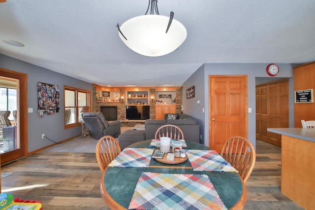 8403 Red Pine Cir, Baxter, MN 56425 - dining space featuring wood finished floors, a textured ceiling, baseboards, a fireplace, and built in shelves