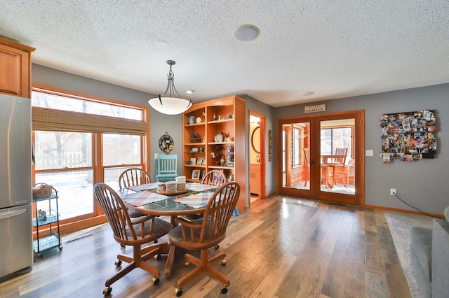 8403 Red Pine Cir, Baxter, MN 56425 - dining area featuring a textured ceiling, light wood-type flooring, and baseboards
