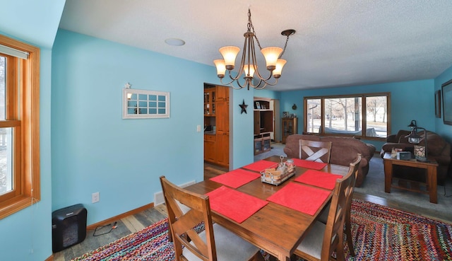 8403 Red Pine Cir, Baxter, MN 56425 - dining area featuring a chandelier, a textured ceiling, and baseboards