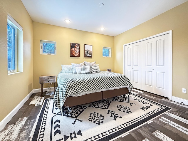 bedroom featuring dark wood finished floors, a closet, and baseboards